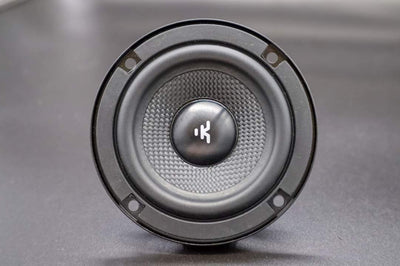 Speaker driver with brand logo on a gray background