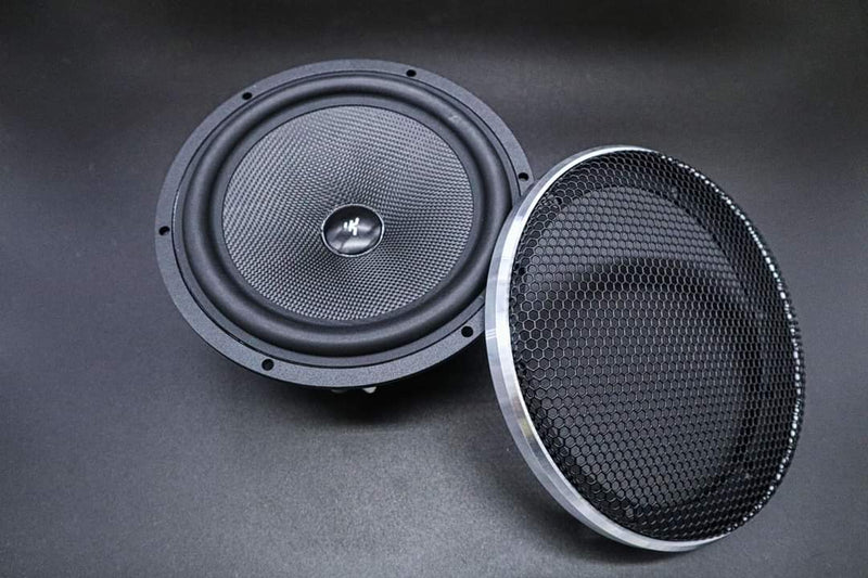 Two speakers, one with a mesh grill and one without, on a dark background