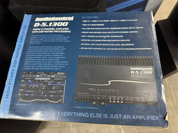 AudioControl D-5.1300 amplifier packaging with text and graphics on a wooden surface