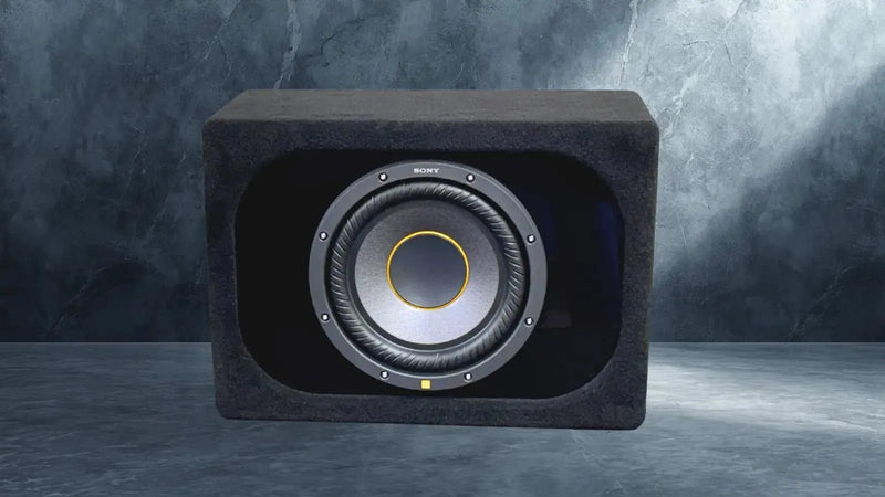 Car subwoofer enclosure with visible brand logo on a gray background