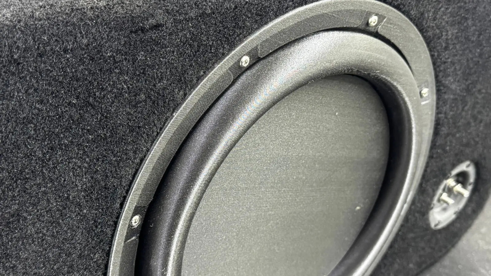 Close-up of a car subwoofer in a black enclosure