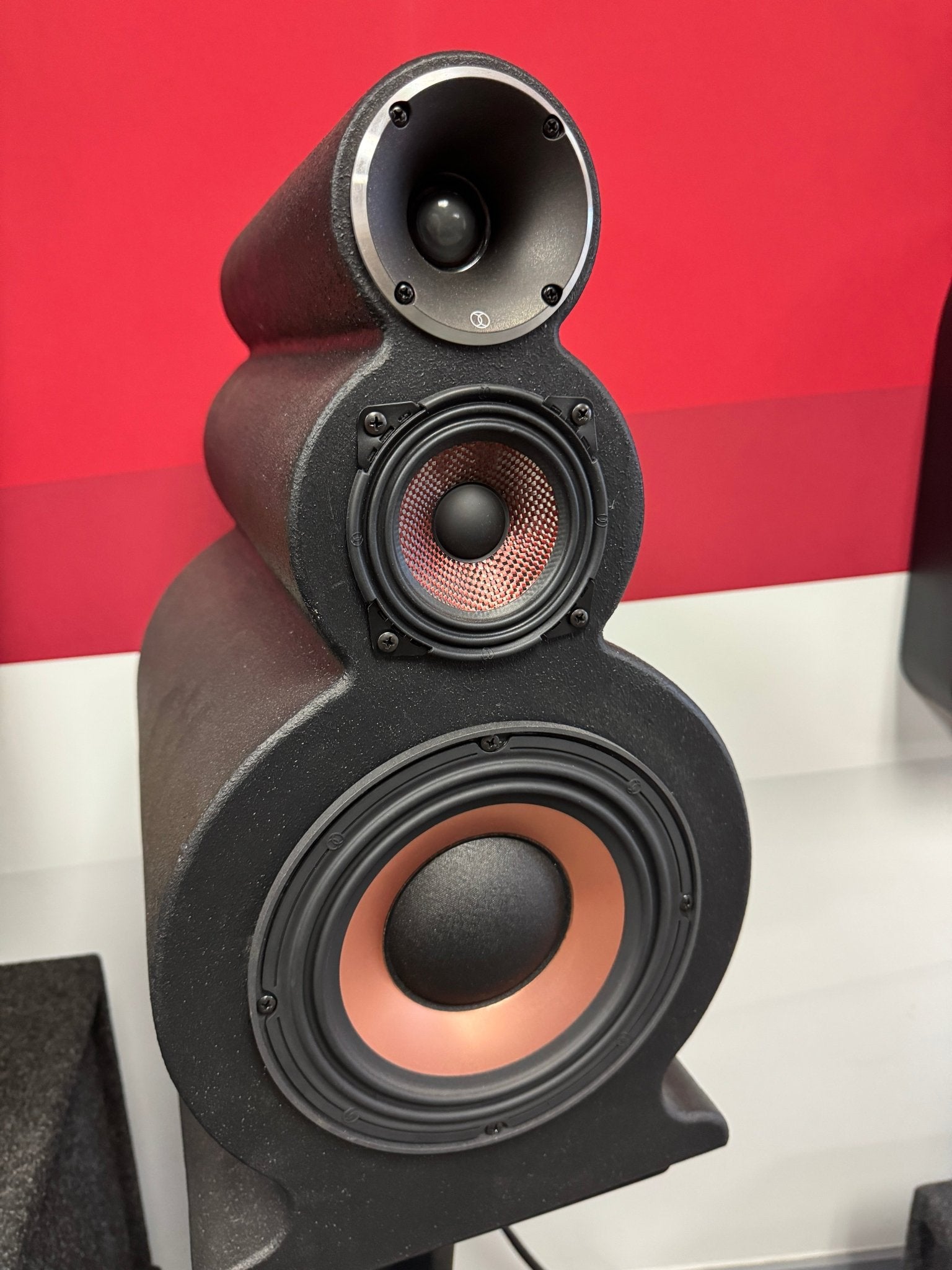 Close-up of a speaker with a red and white background