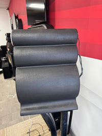 Close-up of a black office chair with red wall in the background